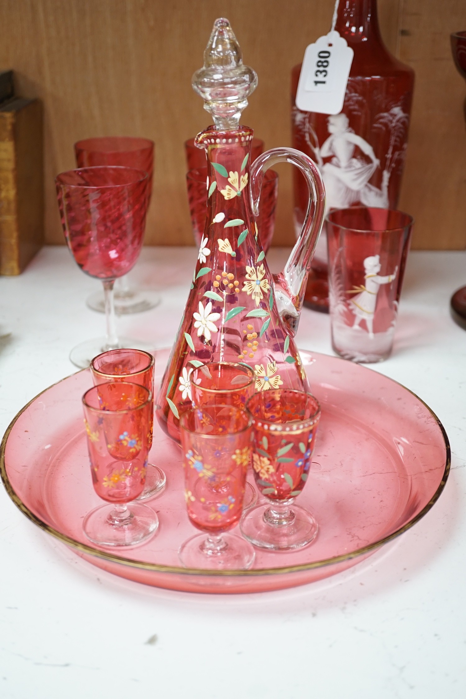 A collection of cranberry glass, a dump paperweight, another and a sweetmeat jar, tallest 28.5 cm